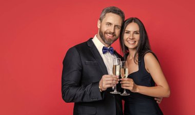 Resmi olarak bir çift. Romantik randevu kutlamaları. Sevgililer Günü. Yıldönümünü kutlayalım. Aşık çift nişanı kutluyor. Zarif çift kırmızıda izole edilmiş şampanya içer. Neşeli çift..