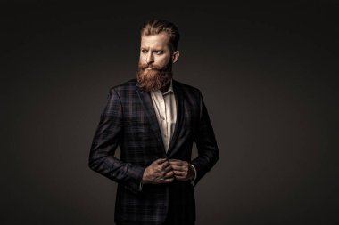 Resmi terzilik kıyafeti. Erkek giyim kuşamı. Bespoke takımı. Özel dikim erkek giysisi giymiş sakallı adam. Özel dikim kıyafet giyen bir iş adamı. Şık takım elbiseli bir iş adamı. Resmi aksesuarlar.
