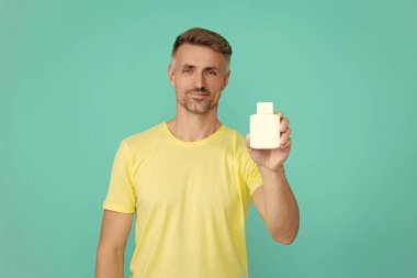 Haplı ya da vitaminli bir adam. Enerji ilacını sunuyorum. Multivitamin ve vitamin. Günlük takviye. İlaç teklif et. Acıyı dindirmek için ilaç. İnsan maviden yiyecek desteğini ayırır. İlaç..
