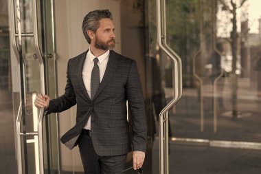 CEO ofise giriyor. İş adamı. Başarılı bir iş adamı ofise giriyor. Olgun girişimci ofis kapısı. Takım elbiseli Amerikalı işadamı ofis binasını terk ediyor. Nüfuzlu iş adamı.