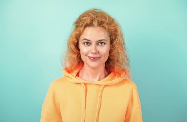 Mavi üzerine kapüşonlu giyen kadın. Moda modeli. Şık kapüşonlu kızıl saçlı kız. Sıradan kapüşonlu, şık, beyaz bir kadın. Modayla ilgilenen kız modaya uygun ve parlak görünüyor. Kapüşonlu.