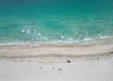 Yazın deniz kenarında tatil. Deniz güneşin altında rahatlar. Denize açılın. Kristal berrak turkuaz suyla kumsalın havadan görünüşü. Plaj güneşinin tadını çıkarıyorum. Cennette yaz tatili.