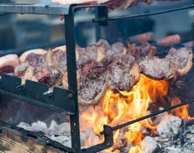 Kızarmış biftek. Izgara Picanha. Arka bahçede barbekü. Aile barbeküsü. Picanha barbeküsü kızgın kömürlerin üstünde kızartılıyor. Mangalda sığır eti. Biftek lokantasında biftekçi. Sokak yemeği..