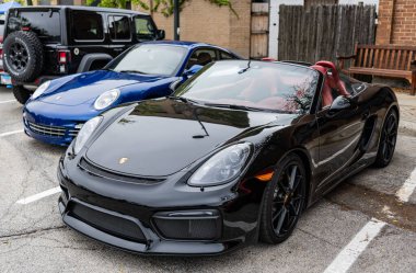 Chicago, Illinois - 29 Eylül 2024: 2016 Porsche Cayman GT4 siyah renk. 2016 model Porsche Cayman GT4 sokağa park etmiş. Köşeden bak. 2016 Porsche Cayman GT4, Chicago