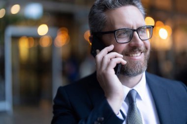 Çıkıyor ve başarılı bir iş adamı ofisten iş görüşmesi yapıyor. Açık alanda, kopyalama alanında..