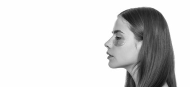 Göz altı yamaları kullanan genç bir kadın, kopyalama alanı. Göz bantlı güzel bir kadın mükemmel bir cilde sahip. Kolajen hidrojel göz bantları. Göz altı nemlendirici bantlı cilt. Reklam..