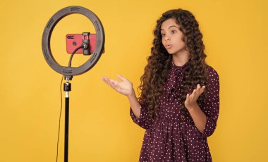 şaşırmış kıvırcık saçlı çocuk blog için video yapıyor.