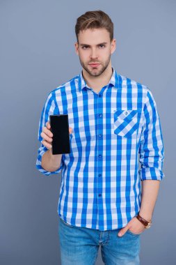 Ürünü sunuyorum. İş uygulamasının reklamı. Milenyum iş adamı telefon ekranını sunuyor. İş adamı Grey 'de izole edilmiş bir telefon gösteriyor. Yeni iş telefonu uygulaması gösteren bir adam.