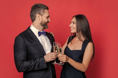 Sevgililer Günü. Yıldönümünü kutlayalım. Aşık çift nişanı kutluyor. Zarif çift kırmızıda izole edilmiş şampanya içer. Resmi olarak bir çift. Romantik randevu kutlamaları. Özel aşk randevusu.