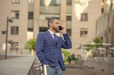 İş adamı telefonda konuşuyor. İş adamı ön ofiste. Sosyal ağ. Telefon şirketinde çalışan İspanyol bir iş adamı. Akıllı telefon kullanan bir iş adamı. Şehirdeki erkek telefon konuşmaları. Cep telefonu.