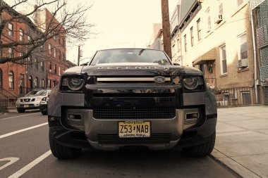 New York City, ABD - 1 Nisan 2024: 2020 Land Rover Defender L663 SUV araba açık havada park edilmiş, alçak görüş.