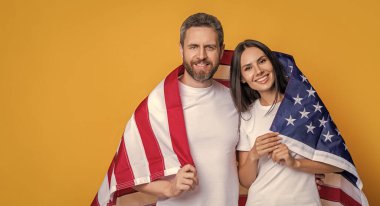 Bayrağa sarılı Amerikalı ruh çifti kutlamak, reklam. Bayrağı olan Amerikalı bir çift. Amerikan bayrağıyla gururla poz veren bir çift. Amerikan bayrağı taşıyan çiftin vatanseverliği.