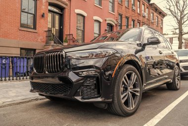 New York City, ABD - 1 Nisan 2024: BMW X7 lüks geçiş aracı açık hava, köşe manzaralı.