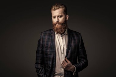 Özel dikim erkek giysisi giymiş sakallı adam. Özel dikim kıyafet giyen bir iş adamı. Şık takım elbiseli bir iş adamı. Resmi terzilik kıyafeti. Erkek giyim kuşamı. Bespoke takımı. Akşam yemeği ceketi.