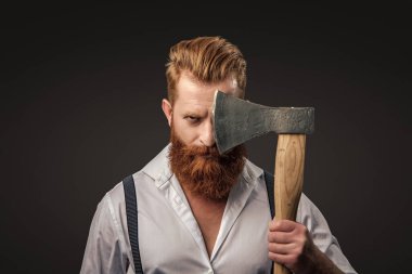 Erkek vahşeti. Antika pantolon askılı, eski tip bir gaddar adam. Siyaha izole edilmiş baltalı askılı vahşi bir adam. Saçları kızıl saçlı, olgun bir adam. Acımasız erkek modası. Gerçek adam..