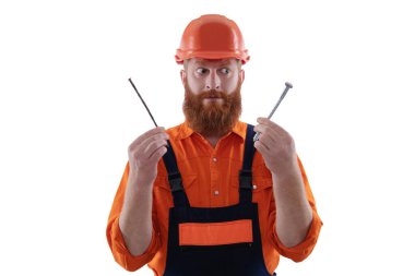 Marangozluk tamir ve çekiç. Üniformalı tamircinin çivisi var. Sakallı marangoz çivi tutar. Marangoz, çivi beyazı ile onarıyor. Tamirci. Adam çekiç çivisi tutuyor. Doğru boyut seçiliyor.