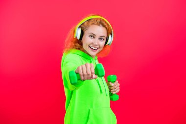 Spor salonunda spor aletleri olan kadın antrenmanı. Pembe üzerine izole edilmiş..