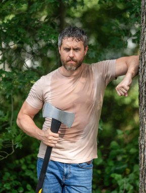 Ormanda baltayla dolaşan oduncu İspanyol adam. Oduncu baltayı taşır. Baltalı terli adam. Ormanda baltayla oduncu. Ağır baltalı oduncu. Güçlü terleyen adam ormanda çalışıyor..