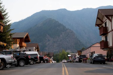 Leavenworth, Washington, ABD - 22 Temmuz 2024: Turistik kasaba. Washington, Leavenworth 'teki Bavyera köyünde yolda ve caddelerde park halindeki arabalarla. Eski kasabadaki yol. Bavyera köyü dağı.