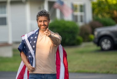 Bağımsızlık Günü için Amerikan Bayrağı ya da 4 Temmuz. Adam Amerikan bayrağını dışarıda tutuyor. Vatansever bir adam ve işaret parmağı var. Amerikan bağımsızlığı. Ulusal bayrak. Bağımsızlık Günü, bayrak.