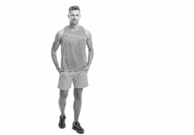 Tam boy atlet gülüşü, kopyalama alanı. Spor giyen sporcu tek başına ayakta duruyor. Erkek sporcu stüdyoda poz veriyor. Formda vücudu beyaza karşı izole bir sporcu. Spor ve sağlıklı yaşam tarzı.