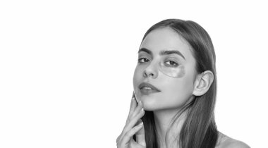 Göz altı nemlendirici bantlı cilt. Göz altı yamaları kullanan genç bir kadın, kopyalama alanı. Göz bantlı güzel bir kadın mükemmel bir cilde sahip. Kolajen hidrojel göz bantları. Göz kremi kullan..