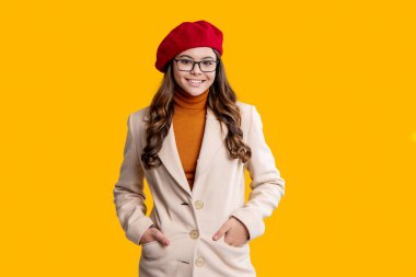 Hırslı kız gözlük takıyor. Sonbahar stil kızı. Moda ve şık bir öğrenci kız gülümsüyor. Gençler için sonbahar stili. Gençlik modelinin sonbahar havası. Sonbahar montlu kız, sarıya bürünmüş..