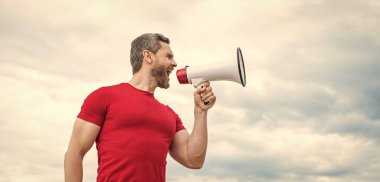 man in red shirt shout in loudspeaker on sky background.