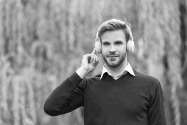 smiling young handsome man listen music in headphones outdoor.