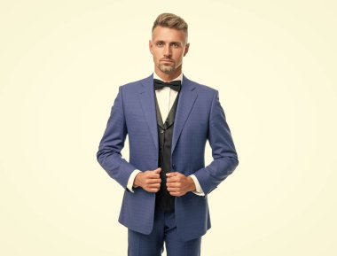 handsome man in bow tie blue suit. businessman isolated on white. gentleman in formal wear.