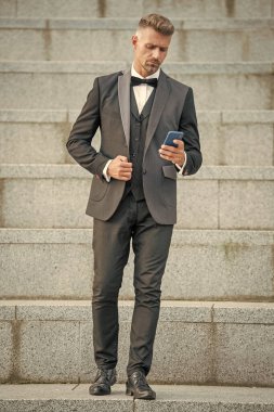 Papyon takım elbiseli şık bir adam. İş adamı telefonu kullanıyor. Patron akıllı telefondan konuşuyor..