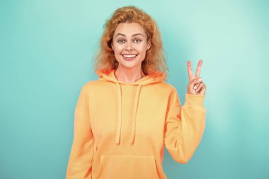 Mavi üzerine kapüşonlu giyen kadın. Moda modeli. Şık kapüşonlu kızıl saçlı kız. Sıradan kapüşonlu, şık, beyaz bir kadın. Modayla ilgilenen kız modaya uygun ve parlak görünüyor. Kapüşonlu.