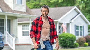 Arka bahçede baltayla oduncu. Ağır baltalı oduncu. Sıkı çalışmadan sonra terleyen güçlü bir adam. Evin önünde baltası olan oduncu adam. Oduncu baltayı taşır. Baltalı terli adam.