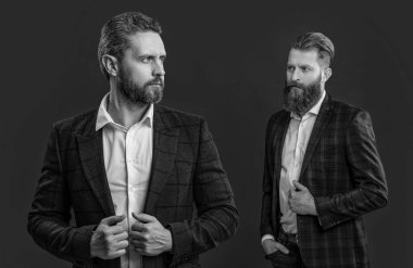 Şık takım elbiseli smokinli adamlar kırmızıda izole edilmiş. Erkek giyim bölümünde smokin giyen adamlar. Smokinli adamlar zarif ceket giyerler. Formalite içinde zarif erkekler. Zarafet ve tarz. İş etkinliğindeki iki iş adamı. Klasik görünüş..