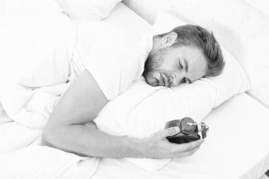 Uykucu adam yatakta yatarken elindeki çalar saate bakıyor. Sabah uyanışı. Uykulu adam çalar saati kapatıyor. Erken kalkmak. Uyanma ve kalkma vakti geldi. Sabah uyanıyor..