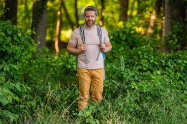 Kırsalda yürüyüş yapan bir adam. Ormandaki İspanyol adam. Ormanda yürüyüş yapan sırt çantalı bir yürüyüşçü. Erkek yürüyüşçü ormanda yürüyor. Sırt çantalı bir gezgin. Yürüyüş macerası. Seyahat yaşam tarzı.