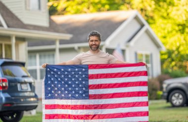 Vatanseverlik sembolü olan bir vatansever. Amerikan bağımsızlığı. Ulusal bayrak. Bağımsızlık Günü. Bağımsızlık Günü için Amerikan Bayrağı ya da 4 Temmuz. Adam Amerikan bayrağını dışarıda tutuyor. Anma Günü.