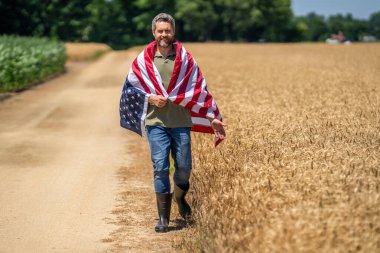 Amerikan İşçi Bayramı. Amerikan bayrağı ve çiftçi, tarım. ABD bayrağı. Bağımsızlık Günü. Sahadaki adam. Ekin tarlasında Amerikan bayrağı taşıyan adam. Amerika 'nın Bağımsızlık Günü. 4 Temmuz.