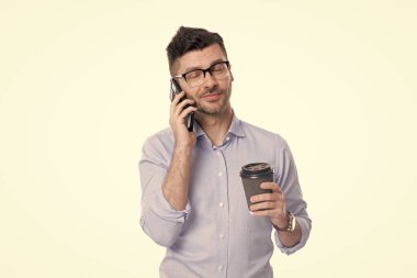 Adam iş konuşuyor. Telefon var. İş adamı iletişim için telefonu kullanıyor. Kahveli bir iş adamı beyazın üstüne izole edilmiş. Kahve molası. İş iletişimi. Satış çağrısı.