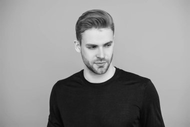 Adamın şık bir saç kesimi var. Moda saç stili olan bir adam. Sıradan erkek tarzı. Beyazlı genç bir adam gri yolda izole edilmiş. Kendine güvenen adam portresi. Erkeklerin cilt bakımı. Erkek derisi. Yakışıklılık.