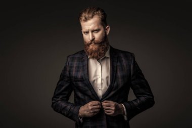 Özel dikim kıyafet giyen bir iş adamı. Şık takım elbiseli bir iş adamı. Resmi terzilik kıyafeti. Erkek giyim kuşamı. Bespoke takımı. Özel dikim erkek giysisi giymiş sakallı adam. Gece kıyafeti takımı..