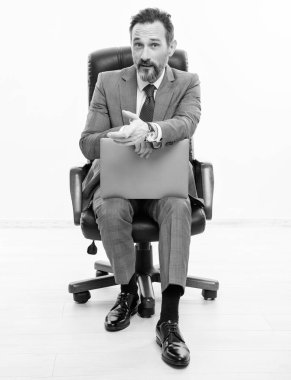 Çevrimiçi çalışan serbest çalışan biri. Adamın online blogu var. Ofis koltuğunda dizüstü bilgisayarı olan takım elbiseli bir iş adamı. Uzaktan kumandalı çalışıyor. İş blogu başarısı. Beyazda izole edilmiş dizüstü bilgisayar kullanan bir iş adamı. iş teklif et.