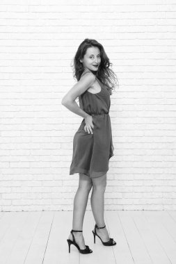 Beyaz tenli kadın, beyazın üzerinde yalnız poz veriyor. Mankenler elbise giyer. Zarif ve zarif bir kadın. Şık, sıradan tarzda şık bir kız. Moda elbisesi içinde genç ve güzel bir kadın. Tam uzunluk.