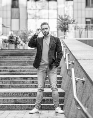 Erkek giysili adam dışarıda bekliyor. Ceketli bir adamın fotoğrafı. Açık havada erkek giyim bölümünde bir adam. Sokaktaki erkek giyim mağazası..