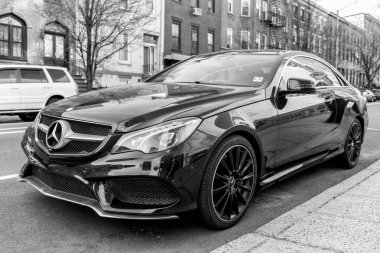 New York City, ABD - 15 Mart 2024: 2014 Mercedes Benz E550 lüks araba, köşedeki manzara.