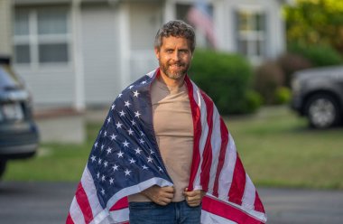 Amerikan bağımsızlığı. Ulusal bayrak. Bağımsızlık Günü. Bağımsızlık Günü için Amerikan Bayrağı ya da 4 Temmuz. İspanyol adam Amerikan bayrağını açık havada tutuyor. Vatanseverlik sembolü olan bir adam..
