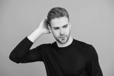 Erkek derisi. Adamın şık bir saç kesimi var. Moda saç stili olan bir adam. Sıradan erkek tarzı. Beyazlı genç bir adam gri yolda izole edilmiş. Kendine güvenen adam portresi. Erkeklerin cilt bakımı. Tatlı ve Yakışıklı.