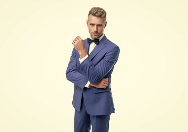 Beyaz arka planda, mavi renkli smokin giymiş olgun bir damat..