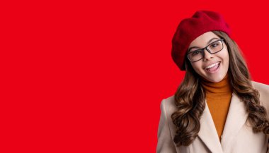 Mutlu portre, uzay afişini kopyala. Genç bir kız. Sonbahar moda kızı. Moda ve şık bir genç kız. Gençler için sonbahar moda tarzı. Sonbahar tarzının modaya uygun portresi. Sonbahar montlu kız kırmızıda izole edilmiş..