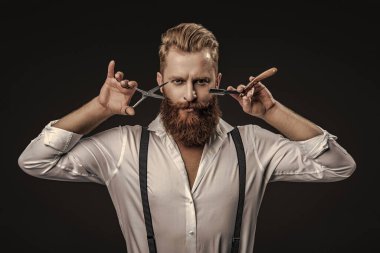 Profesyonel berber, retro traş makinesini tutar. Saç tıraşı olan yakışıklı bir kuaför. Berber dükkanı. Erkek kuaförlüğü ve berberlik. Berber dükkanındaki kuaför siyahta izole edilmiş. Kuaför. Saç stili.